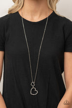 Load image into Gallery viewer, A silver heart engraved with the word &quot;Grandma,&quot; dangles from two smaller hearts at the bottom of a lengthened silver chain. The first heart is accented with sparkly white rhinestones creating an affectionately sentimental pendant. Features an adjustable clasp closure.  Sold as one individual necklace. Includes one pair of matching earrings.
