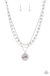 Infused with a strand of metallic flecked hematite crystal-like beads, two dainty rows of mismatched silver chains delicately layer below the collar. Stamped in the word, "Grandma," a shiny silver disc swings from the lowest chain, creating a loving pendant. Features an adjustable clasp closure.  Sold as one individual necklace. Includes one pair of matching earrings.