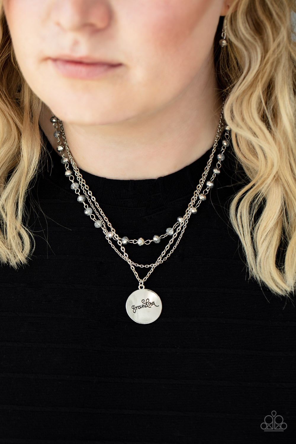 Infused with a strand of metallic flecked hematite crystal-like beads, two dainty rows of mismatched silver chains delicately layer below the collar. Stamped in the word, 