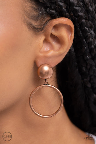 Brushed in an antiqued shimmer, a copper hoop swings from the bottom of an oversized copper stud for a classic metallic look. Earring attaches to a standard clip-on fitting.  Sold as one pair of clip-on earrings.