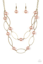 Load image into Gallery viewer, Two rows of pearly brown beads and brass oval frames alternate below the collar, creating luminescent layers. Features an adjustable clasp closure.  Sold as one individual necklace. Includes one pair of matching earrings.
