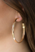 Load image into Gallery viewer, Featuring edgy diamond-cut texture, a glistening gold hoop curls around the ear in a bold industrial fashion. Earring attaches to a standard post fitting. Hoop measures 2 1/4” in diameter. Sold as one pair of hoop earrings.
