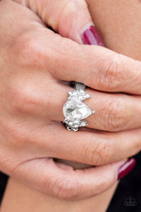 A dramatic white teardrop gem is pressed into the center of a dainty silver band. Featuring regal marquise-cuts, dainty white rhinestones flank the sparkling teardrop center for a glamorous finish. Features a dainty stretchy band.  Sold as one individual ring.