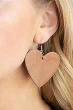 Load image into Gallery viewer, A brown tan leather heart frame swings from the ear for a flirtatiously neutral pop of color. Earring attaches to a standard fishhook fitting.  Sold as one pair of earrings.
