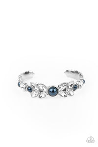 Dotted with bubbly blue pearls, an oversized collection of round and marquise style white rhinestones boldly coalesce into a sparkly centerpiece that is flanked by stacks of leafy silver frames that gracefully curve into a decorative cuff.  Sold as one individual bracelet.