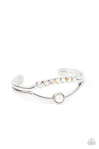 A row of iridescent rhinestones and a solitaire white pearl adorn the layered center of a classic silver cuff, creating a timeless piece around the wrist.  Sold as one individual bracelet.