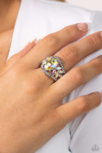 Bordered in dainty rows of glassy white rhinestones, leafy iridescent rhinestones bloom from a dramatically oversized iridescent rhinestone that coalesces into a glamorous centerpiece atop the finger. Features a stretchy band for a flexible fit. Due to its prismatic palette, color may vary.  Sold as one individual ring.