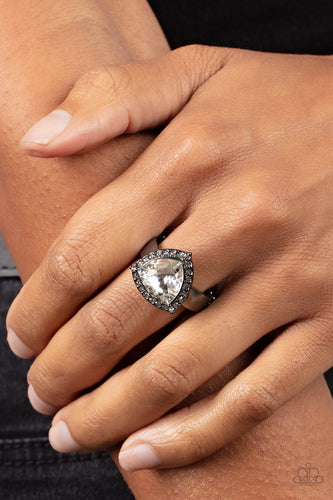 An oversized trilliant cut white rhinestone encased in a sparkling rhinestone-encrusted gunmetal frame steals the spotlight and creates an eye-catching stunner atop the finger. Features a dainty stretchy band for a flexible fit.  Sold as one individual ring.