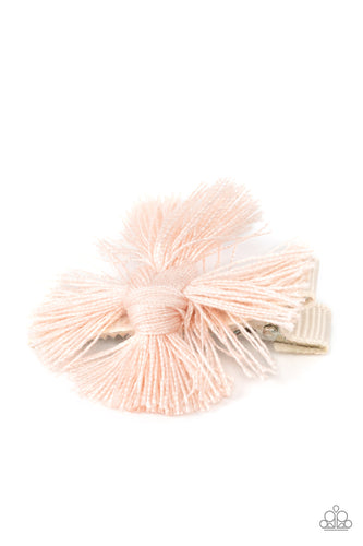 An earthy fringe of pale pink tassels are knotted together to form a boho-chic style over a white ribbon clip. Features a standard hair clip on the back.  Sold as one individual hair clip.
