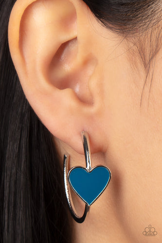 A charming Mykonos Blue heart adorns the front of a classic silver hoop resulting in a whimsical fashion. Earring attaches to a standard post fitting. Hoop measures approximately 1 1/4