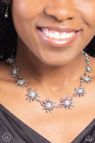 Featuring studded silver or white rhinestone encrusted centers, lifelike silver daisies gradually increase in size as they link around the necklace for a fashionably floral display. Features an adjustable clasp closure.  Sold as one individual choker necklace. Includes one pair of matching earrings.