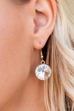 Load image into Gallery viewer, Rhinestone hanging from a gold fish hook earring.
