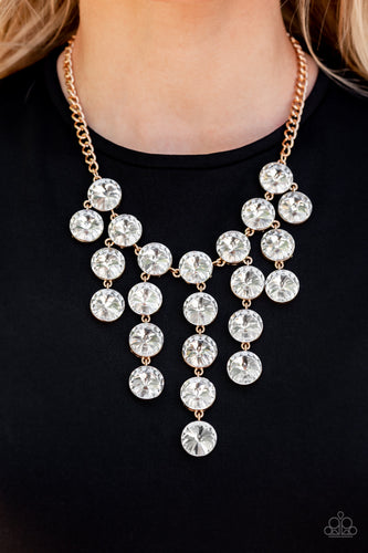 Encased in glistening gold fittings, dramatically oversized white rhinestones delicately link into twinkly tassels that taper off into a jaw-dropping fringe below the collar. Features an adjustable clasp closure.  Sold as one individual necklace. Includes one pair of matching earrings.