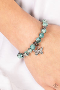 Infused with a silver butterfly charm, textured silver accents and black speckled blue stone beads are threaded along stretchy bands around the wrist for a whimsical look.  Sold as one individual bracelet.