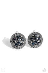 A glitzy collection of blue and hematite rhinestones are encircled with a silver rope-like border, resulting in a smoldering centerpiece. Earring attaches to a standard clip-on earrings.  Sold as one pair of clip-on earrings.