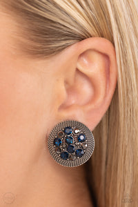 A glitzy collection of blue and hematite rhinestones are encircled with a silver rope-like border, resulting in a smoldering centerpiece. Earring attaches to a standard clip-on earrings.  Sold as one pair of clip-on earrings.