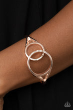 Load image into Gallery viewer, Encrusted in sections of glassy white rhinestones, two oversized rose gold rings delicately overlap across the center of the wrist, resulting in a timeless bangle-like bracelet around the wrist. Features a hinged closure.  Sold as one individual bracelet.

