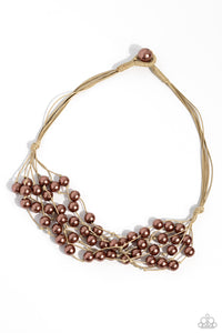 A collection of bubbly brown pearls are knotted in place along strands of shiny tan cording, resulting in boisterous layers below the collar. Features a button-loop closure.  Sold as one individual necklace. Includes one pair of matching earrings.