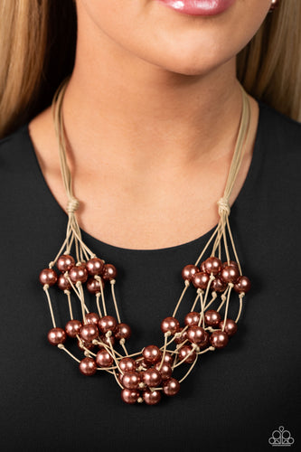 A collection of bubbly brown pearls are knotted in place along strands of shiny tan cording, resulting in boisterous layers below the collar. Features a button-loop closure.  Sold as one individual necklace. Includes one pair of matching earrings.