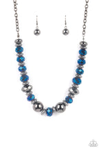 Load image into Gallery viewer, A dramatic assortment of oversized gunmetal beads, textured gunmetal rings, and faceted metallic blue gems delicately glides along an invisible wire below the collar, resulting in a stellar sparkle. Features an adjustable clasp closure. Includes one pair of matching earrings.
