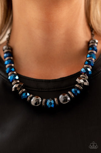 A dramatic assortment of oversized gunmetal beads, textured gunmetal rings, and faceted metallic blue gems delicately glides along an invisible wire below the collar, resulting in a stellar sparkle. Features an adjustable clasp closure. Includes one pair of matching earrings.