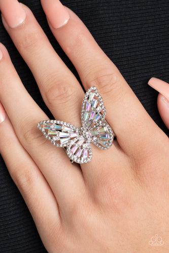 A glitzy collection of emerald cut iridescent rhinestones are sprinkled across the studded wings of a shiny silver butterfly, resulting in a whimsical centerpiece atop the finger. Features a stretchy band for a flexible fit.  Sold as one individual ring.