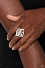 Load image into Gallery viewer, An oversized iridescent oval gem is flanked by a pair of iridescent teardrop rhinestones atop a white rhinestone dotted frame, resulting in a dramatic dazzle atop the finger. Features a stretchy band for a flexible fit. Due to its prismatic palette, color may vary.  Sold as one individual ring.
