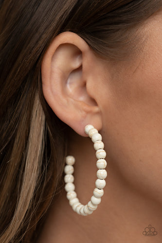 Earthy white stone beads are threaded along a dainty wire hoop, resulting in an earthy flair. Earring attaches to a standard post fitting. Hoop measures approximately 2
