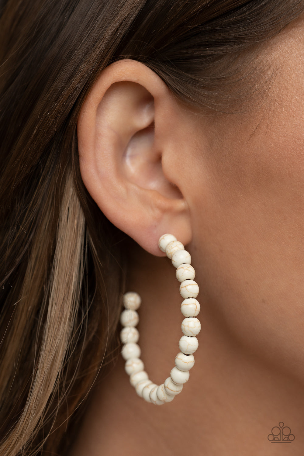 Earthy white stone beads are threaded along a dainty wire hoop, resulting in an earthy flair. Earring attaches to a standard post fitting. Hoop measures approximately 2