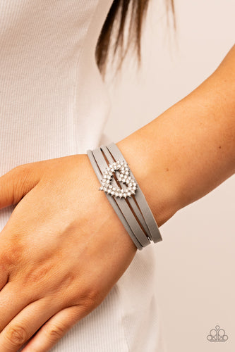 Featuring pronged silver fittings, two rows of glassy white rhinestones stack into a sparkly heart frame that is threaded along layers of Ultimate Gray leather strands around the wrist. Features a magnetic closure.  Sold as one individual bracelet.