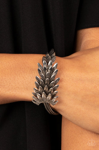 Feathery silver frames delicately overlap across the center of the wrist, creating a boa-like centerpiece atop rows of rustic silver chains. Features an adjustable clasp closure.  Sold as one individual bracelet.