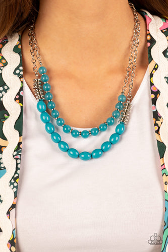 Infused with silver accents, rows of glassy and acrylic blue beads are threaded along invisible wires at the bottom of two silver chains that layer into a vivacious pop of color below the collar. Features an adjustable clasp closure.  Includes one pair of matching earrings.