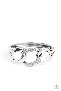 A trio of rounded square silver links, featuring a hammered texture, interlock into an unapologetic display. The centermost link is dotted with glassy rhinestones, creating a sparkly fashion around the wrist. Features a hinged closure.  Sold as one individual bracelet.