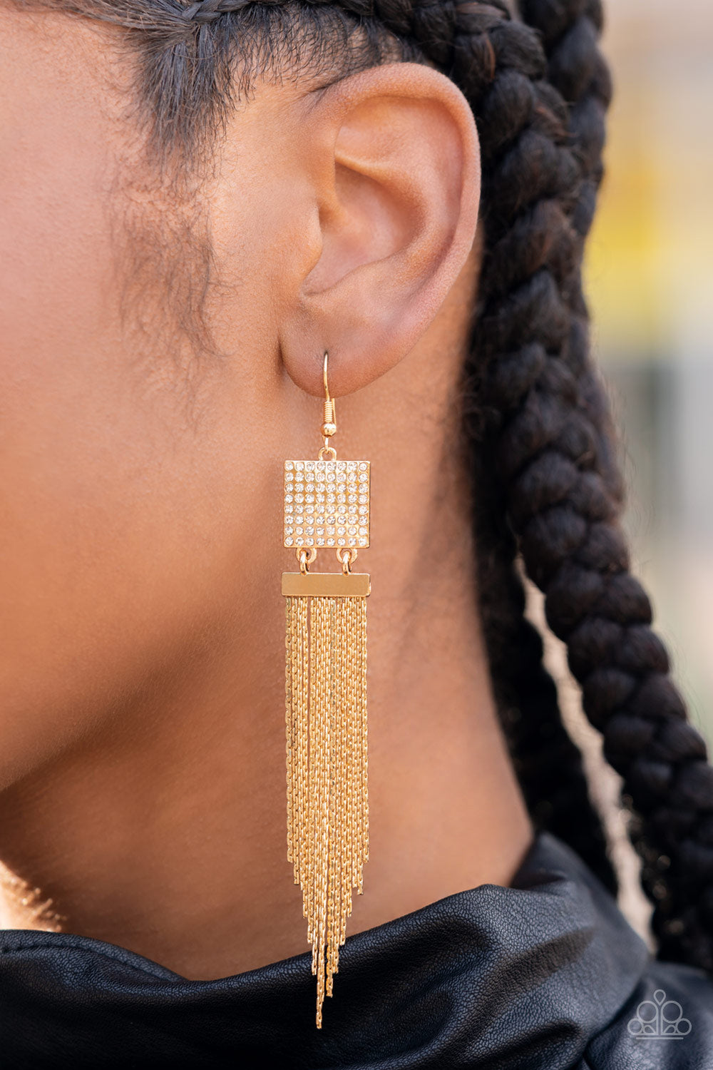 A tapered curtain of flat gold chains cascades from a gold rectangular fitting that delicately links to a gold square frame dotted in dainty white rhinestones, resulting in a trendy tassel. Earring attaches to a standard fishhook fitting.  Sold as one pair of earrings.
