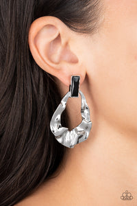 Folds of warped silver delicately gather into an edgy teardrop at the bottom of an emerald cut black rhinestone. Earring attaches to a standard post fitting.  Sold as one pair of post earrings.