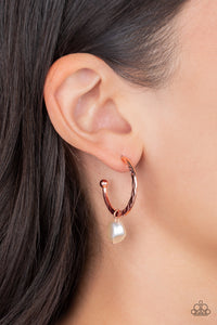 An imperfect white pearl glides along a hammered shiny copper hoop, creating a timeless twist. Earring attaches to a standard post fitting. Hoop measures approximately 1" in diameter.  Sold as one pair of hoop earrings.