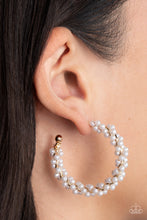Load image into Gallery viewer, A dainty strand of white pearls is delicately wrapped around a classic gold hoop, creating bubbly refinement. Earring attaches to a standard post fitting. Hoop measures approximately 1 1/2&quot; in diameter.  Sold as one pair of hoop earrings.
