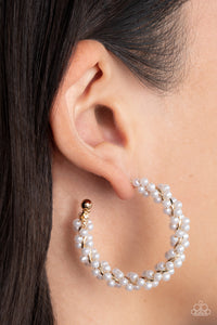 A dainty strand of white pearls is delicately wrapped around a classic gold hoop, creating bubbly refinement. Earring attaches to a standard post fitting. Hoop measures approximately 1 1/2" in diameter.  Sold as one pair of hoop earrings.