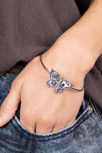Load image into Gallery viewer, A silver butterfly with blue teardrop rhinestone wings and a white-rhinestone body delicately perches atop a shiny silver cuff.  Sold as one individual bracelet.
