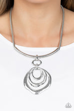 Load image into Gallery viewer, Warped silver hoops glisten from the bottom of a bowing silver bar set in the center of a rounded silver snake chain, resulting in a contemporary centerpiece below the collar. Features an adjustable clasp closure.  Sold as one individual necklace. Includes one pair of matching earrings.
