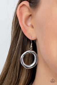 Warped silver hoops glisten from the bottom of a bowing silver bar set in the center of a rounded silver snake chain, resulting in a contemporary centerpiece below the collar. Features an adjustable clasp closure.  Sold as one individual necklace. Includes one pair of matching earrings.