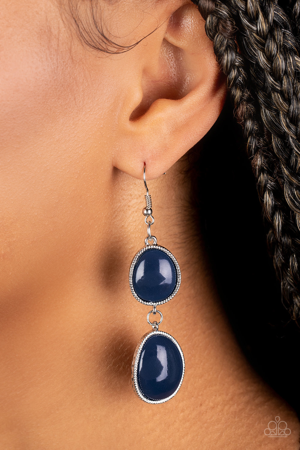 Set in textured silver frames, two asymmetrical navy blue beads link into a colorful lure for a summery fashion. Earring attaches to a standard fishhook fitting. /P>  Sold as one pair of earrings.