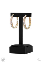 Load image into Gallery viewer, The front-facing surface of a chunky gold hoop is dipped in brilliantly sparkling white rhinestones while light-catching texture wraps around the back. The interior of the hoop features the opposite pattern, creating the illusion of a full hoop of blinding Blockbuster rhinestones. Earring attaches to a standard post fitting. Hoop measures 1 3/4&quot; in diameter.  Sold as one pair of hoop earrings.
