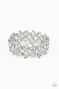 Round and marquise-cut white gems intertwine around polished silver studs and ornate feather-like details in a glitzy pattern. The textured, glittery display is threaded along elastic stretchy bands for a whimsical finish.  Sold as one individual bracelet.