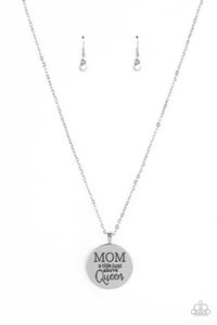 At the bottom of a shiny silver chain, a shiny silver disc is stamped with the phrase, "MOM a title just above Queen." The clasp attaching the disc to the chain features a collection of dainty iridescent rhinestones, adding a hint of sparkle to the sentimental statement piece. Features an adjustable clasp closure. Due to its prismatic palette, color may vary.  Sold as one individual necklace. Includes one pair of matching earrings.