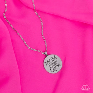 At the bottom of a shiny silver chain, a shiny silver disc is stamped with the phrase, "MOM a title just above Queen." The clasp attaching the disc to the chain features a collection of dainty iridescent rhinestones, adding a hint of sparkle to the sentimental statement piece. Features an adjustable clasp closure. Due to its prismatic palette, color may vary.  Sold as one individual necklace. Includes one pair of matching earrings.