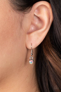 A single  iridescent rhinestone, hanging from a silver fish hook earring.