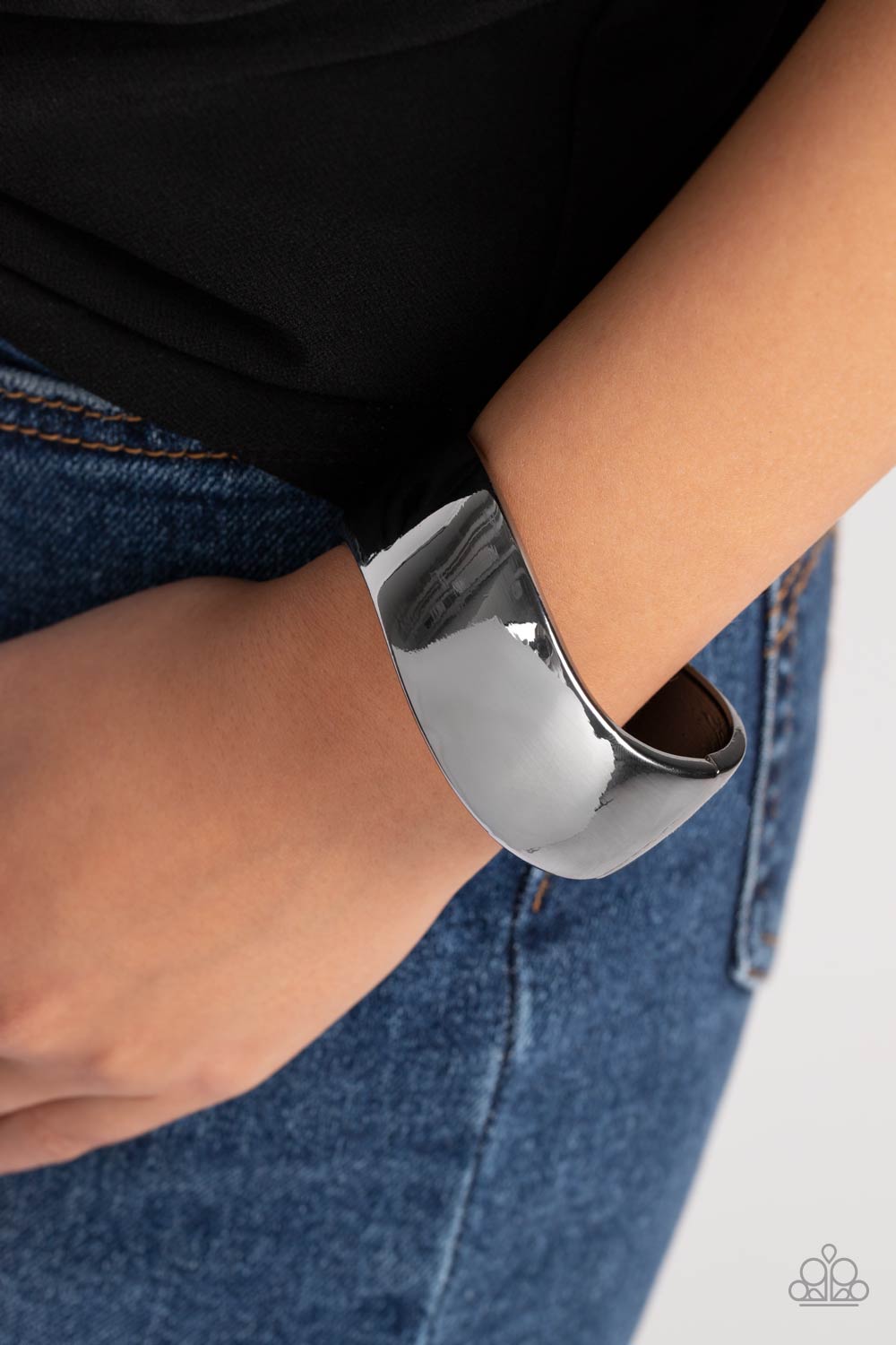 A thick band of gunmetal wraps around the wrist in a dramatic display. As the edges of the band curve into subtle waves, the high sheen finish creates a blinding display of intense sheen that demands attention. Features a hinged closure.  Sold as one individual bracelet.