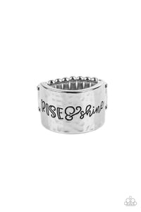 Across a wide silver band with a hammered sheen, the phrase "Rise & Shine" is stamped in varying fonts for a merry message. Features a stretchy band for a flexible fit.  Sold as one individual ring.