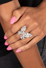 Load image into Gallery viewer, Shiny silver bars curl into the shape of a butterfly, creating a whimsical centerpiece that flutters atop the finger. White opalescent beads fill the inside of the wings, leaving spaces in between for the design to remain airy and light. Finally, tiny white rhinestones line the inside edges of the silver frame, adding a hint of irresistible sparkle to the mix. Features a stretchy band for a flexible fit.  Sold as one individual ring.
